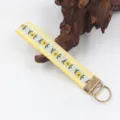Detailansicht eines gewebten Schlüsselanhängers mit Blumenmuster und goldenem Ring - Beige Gelb Floral (04-15F)
