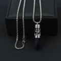 Detail view of a stainless steel music note diffuser necklace with purple crystal - Amethyst