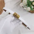 Dettaglio di cintura in pelle bianca con elegante fibbia in metallo dorato per abiti e completi. - Bianco Lucido