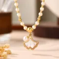 Detailansicht einer eleganten Ginko-Blatt Perlenkette mit funkelnden Zirkon-Steinen - Ginkgoblatt Perlmutt Anhänger / Gold