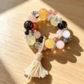 Nahaufnahme eines bunten Kristallperlenarmbands mit silbernen Schmetterlingen und Quaste. - Mehrfarbige Runde Perlenquaste (Stil 9)