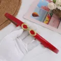 Detail shot of red glossy women's thin leather belt with vintage gold double buckle design. - Glossy Red