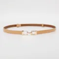 Close-up detail of a fashionable thin patent leather belt with a golden metal buckle. - Glossy Apricot