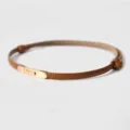 Sottile cintura da donna in pelle marrone, caratterizzata da una elegante fibbia in metallo dorato. - Cammello