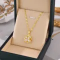 Detail view of gold-plated titanium steel necklace with sparkling stone flower pendant. - Rotating Lucky Clover Pendant / Gold