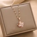 Detailed view of a rose gold flower pendant with sparkling crystals on a jewelry box - Rotating Lucky Clover Pendant / Rose Gold