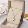 Detail shot of a silver four-leaf clover pendant necklace in a luxury gift box - Rotating Lucky Clover Pendant / Silver
