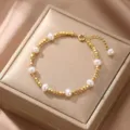 Vista detallada de una pulsera de cuentas doradas con ocho elegantes perlas blancas - Estilo 3