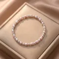 Detail view of a pink oval pearl and silver bead bracelet on a champagne jewelry box - Style 5