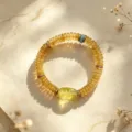 Makroansicht eines natürlichen gelben Kristallperlenarmbands mit Türkis-Akzent auf hellem Papier - Stil 3 / Gelb