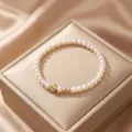 Close-up view of an elegant natural pearl bracelet featuring gold bead accents on a silk box. - Style 11