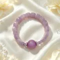 Nahaufnahme eines lila Kristallarmbands mit Diamant-Abstandshaltern auf weißer Seide. - Stil 6
