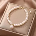 Detailed view of elegant natural pearl bracelet with gold hardware on a silk display - Style 13