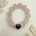 Detailansicht eines Rosenquarz-Armbands mit lila Akzentperle auf Strukturstoff - Stil 10