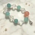 Detailansicht eines handgefertigten Kristallarmbands mit weißen und grünen Perlen - Geschnitzter Hellgrüner Stil mit Rosa Perlenanhänger (款11)