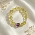 Nahaufnahme von facettierten gelben Kristallperlen und Amethyst auf weißem Seidenstoff - Hellgelber Facettierter Perlen-Stil mit Lilafarbenen Rundperlen (款17)