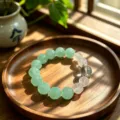 Natural green fluorite crystal beaded bracelet displayed on a wooden tray in natural sunlight - Style 5