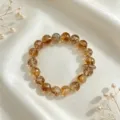 Nahaufnahme eines natürlichen Citrin-Kristallarmbands auf weißem Seidenstoff - Rundperlenarmband (Stil 21)