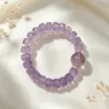 Nahaufnahme des facettierten lila Amethyst-Armbands mit Kristalldistanzstücken auf Seidenstoff - Amethyst Facettierte Würfelperlen Armband (Stil 30)