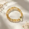 Detailansicht eines eleganten gelben Kristallarmbands auf weißem Seidenhintergrund - Hellgelber Perlenstil mit hellgrünen Akzenten (Stil 31)