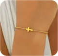 Nahaufnahme eines minimalistischen, vergoldeten Armbands mit horizontalem Kreuz - Goldene Seitwärts Kreuz Glatter Stil