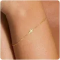 Detailansicht eines zierlichen Goldkettenarmbands mit einem minimalistischen Kreuzanhänger. - Goldene Kleine Kreuz Ankerkette