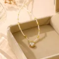Nahaufnahme einer eleganten Perlenkette mit Blumenanhänger und Zirkonia in einer Box - Kleeblatt-Anhänger / Gold