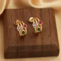 Detailaufnahme goldener Ohrringe mit bunten Zirkoniasteinen auf einem Holzständer - Drei-Ring Mehrfarbiger Zirkonia Stil (Stil 4)