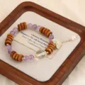 Detailaufnahme eines Sandelholz- und Amethyst-Armbands mit Schmetterlingsanhänger - Amethyst with Butterfly Pendant / Lila