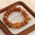 Natürliches Sandelholz-Armband mit geschnitzter Bärenperle und Goldakzenten. - Holzbär-Anhänger-Stil / Rotbraun
