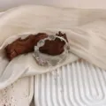 Detailansicht eines Kristallarmbands mit rosa Schneeflocke und silberner Quaste. - Grün