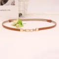 Smalle bruine lederen damesriem met elegante parel metalen gesp voor jurken en truien. - camel