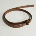 Close-up of brown leather belt with fine stitching details, perfect accessory for dresses. - Caramel color