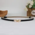 Cintura sottile da donna in pelle verniciata nera con fibbia dorata e perla per abito chic. - Nero