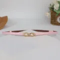 Close-up of pink thin leather belt with elegant pearl metal double buckle detail for women. - Pink