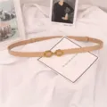 Vista detallada de un cinturón fino minimalista de piel para mujer con hebilla metálica. - Albaricoque