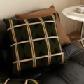 Primo piano di un cuscino geometrico verde scuro in stile retro su divano in pelle. - 35x35 cm (senza interno cuscino) / SBZA041803