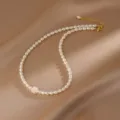 Primo piano di un'elegante collana di perle bianche con ciondolo a camelia in madreperla - Collana