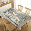 Detailed view of the winter snow scene tablecloth, featuring cozy cabin and deer design for decor. - 5