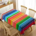Mantel de rayas de colores sobre mesa de madera en escena luminosa de comedor interior. - 70x40cm / Rayas de Arcoíris