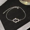 Bracelet élégant en acier titane avec main de Fatma sertie de zircons et œil bleu protecteur. - Style Hamsa Œil Bleu Argenté (Style 22)