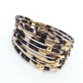Vista detallada de la pulsera envolvente de cuero con estampado de leopardo y tubos dorados. - Amarillo Claro