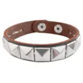 Detalle de primer plano de pulsera de cuero con tachuelas cuadradas punk, marrón. - Una fila marrón oscuro