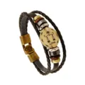 Primer plano de una pulsera de cuero trenzado con un dije vintage del signo zodiacal Libra. - Libra