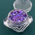 Dettaglio di paillettes esagonali viola cangianti in un barattolo di plastica trasparente - Barattolo / Violetto Iridescente