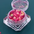 Close-up van roze iriserende zeshoekige glitters voor nail art en creatieve DIY-make-up - Pot / Iriserend rozerood