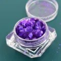 Detailopname van paarse zeshoekige glitters in een heldere vierkante container - Pot / Fantoom paars