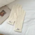 Detailed view of creamy white cable knit winter gloves, cozy, soft, and stylish design. - Milk White