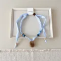 Blauwe gingham stoffen ketting sjaal met kraaltjes en bruine hanger voor chique accessoire. - 13 Barnsteen - Fijn klein ruitje blauw