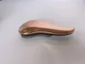 Primo piano della spazzola per capelli galvanizzata in oro rosa con superficie curva. - Dimensioni piccole (lunghezza 15 cm, larghezza 6,5 cm, altezza 2,8 cm) / Oro rosa galvanizzato in busta OPP